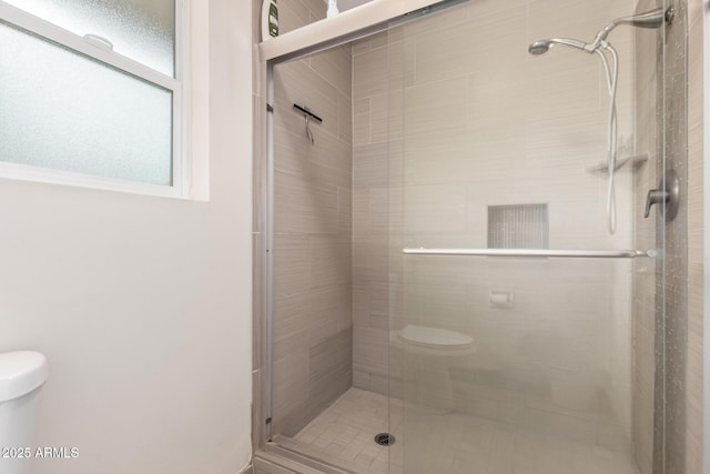 bathroom with toilet and a stall shower