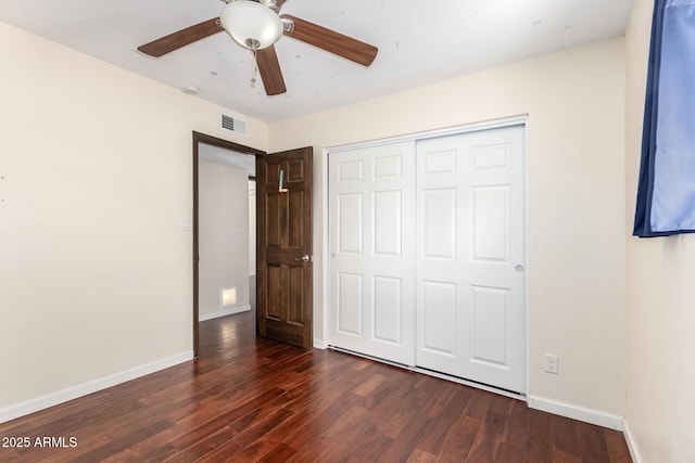 unfurnished bedroom featuring baseboards, dark wood-style floors, visible vents, and a closet