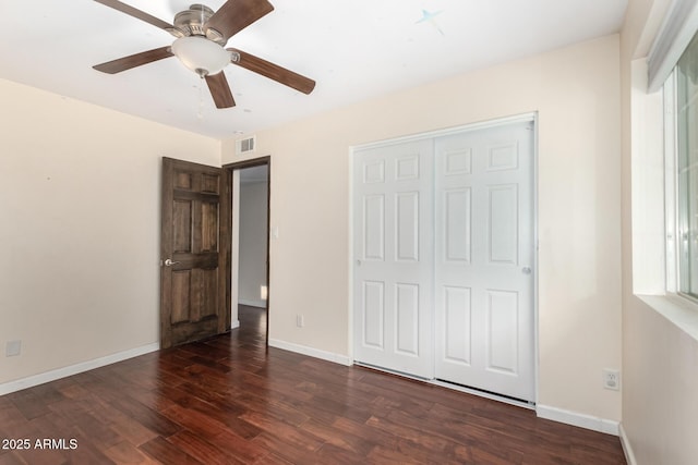 unfurnished bedroom featuring a closet, baseboards, visible vents, and wood finished floors