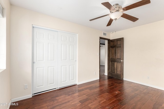 unfurnished bedroom featuring a closet, visible vents, wood finished floors, and baseboards