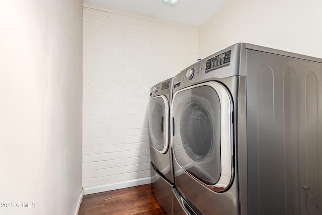 laundry area featuring washer and dryer, laundry area, dark wood finished floors, and baseboards