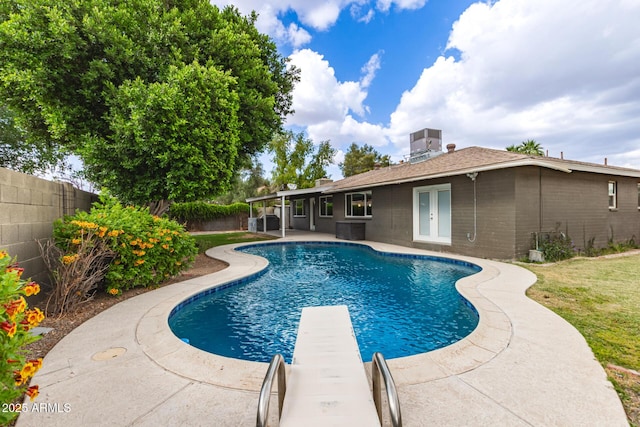 view of pool with a patio, french doors, central AC, a fenced backyard, and a fenced in pool