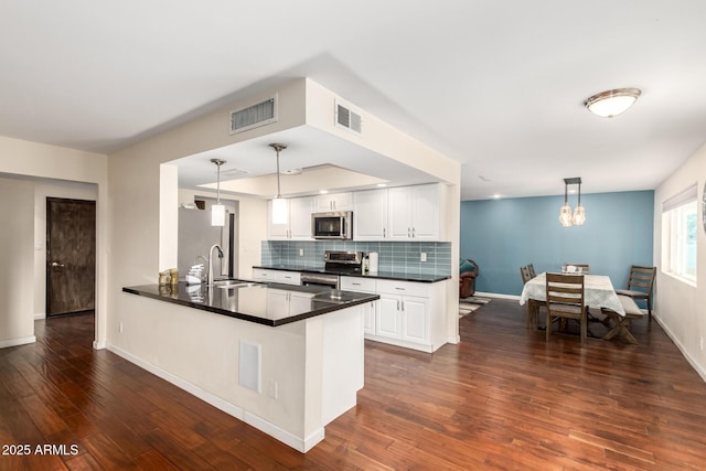 kitchen featuring dark countertops, appliances with stainless steel finishes, visible vents, and a sink