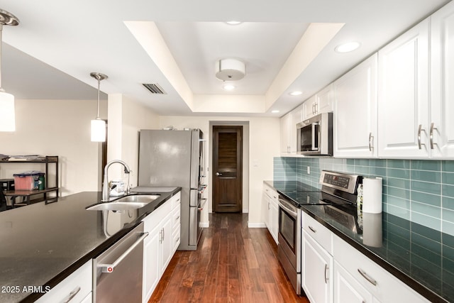 kitchen with white cabinets, appliances with stainless steel finishes, visible vents, and a sink