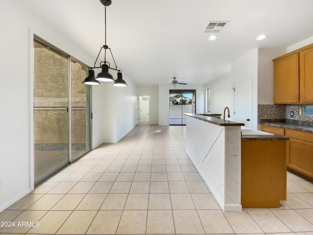 kitchen with hanging light fixtures, a wealth of natural light, ceiling fan, and light tile patterned flooring