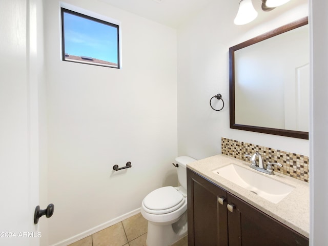 bathroom with tile patterned flooring, vanity, toilet, and backsplash