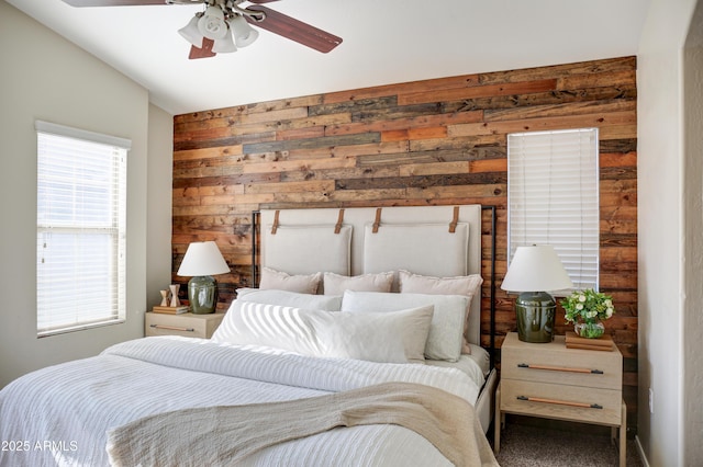 bedroom featuring lofted ceiling, ceiling fan, and wooden walls