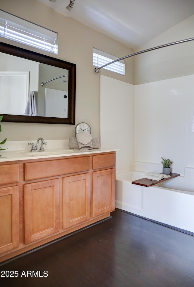 bathroom with shower / bathtub combination, hardwood / wood-style floors, and vanity