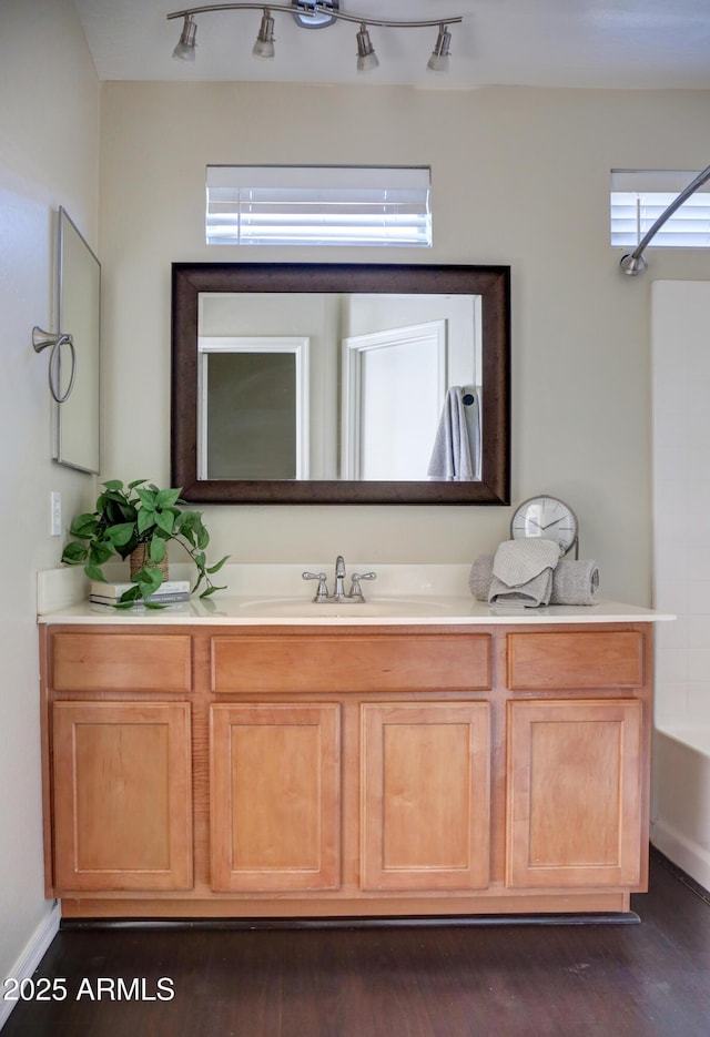 bathroom featuring  shower combination, hardwood / wood-style flooring, and vanity