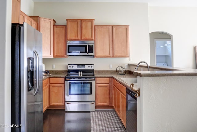 kitchen with stainless steel appliances, kitchen peninsula, and sink