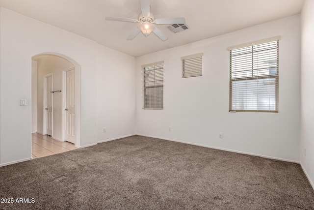 3756 E Kerry Ln, Phoenix, AZ 85050 - spare room with light carpet, ceiling fan, arched walkways, and baseboards