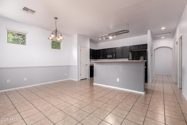 3756 E Kerry Ln, Phoenix, AZ 85050 - kitchen featuring black microwave, light tile patterned flooring, dark cabinets, light countertops, and hanging light fixtures