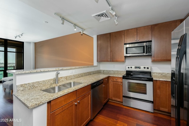 kitchen with rail lighting, a peninsula, visible vents, appliances with stainless steel finishes, and a sink