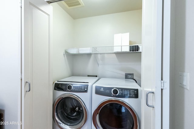 clothes washing area with visible vents, independent washer and dryer, and laundry area