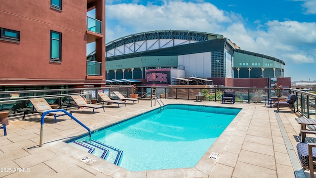 community pool with fence and a patio