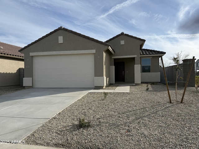 ranch-style house with a tile roof, stucco siding, an attached garage, and concrete driveway