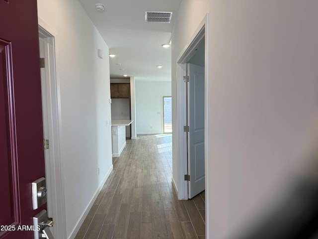 corridor with recessed lighting, wood finished floors, visible vents, and baseboards