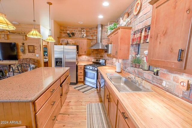 2353 Florian Meadow Trl, Overgaard, AZ 85933 - kitchen with stainless steel appliances, decorative backsplash, a sink, light wood-style floors, and wall chimney exhaust hood