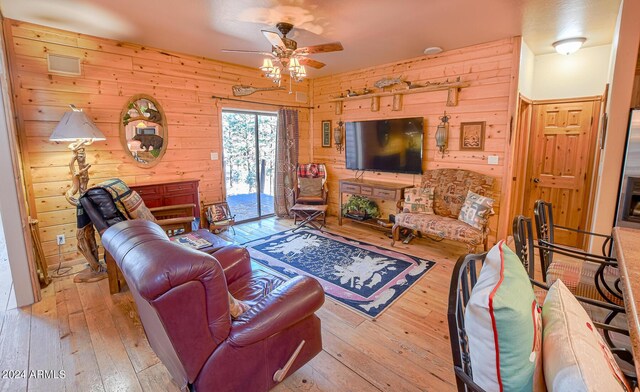 2353 Florian Meadow Trl, Overgaard, AZ 85933 - living room featuring a ceiling fan, wood walls, and hardwood / wood-style floors