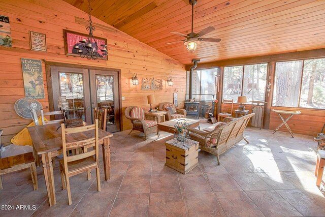 2353 Florian Meadow Trl, Overgaard, AZ 85933 - tiled living room with vaulted ceiling, french doors, wood walls, a wood stove, and ceiling fan