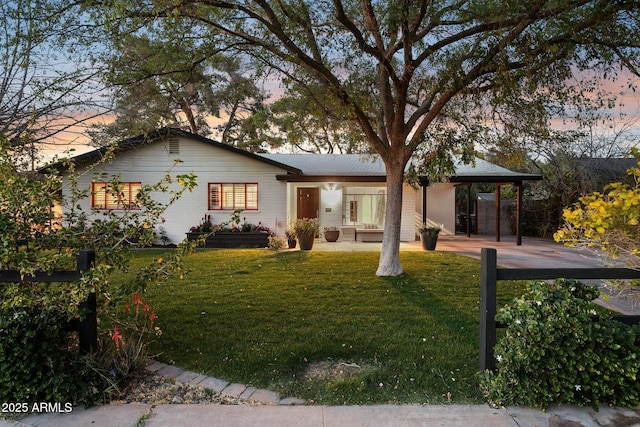 ranch-style home with a front lawn and an attached carport