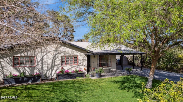 view of front facade featuring a front lawn and an attached carport
