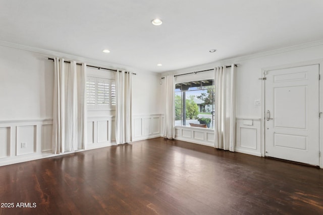 unfurnished room featuring recessed lighting, a decorative wall, crown molding, and wood finished floors