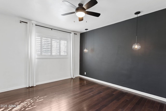spare room featuring ceiling fan, baseboards, and wood finished floors