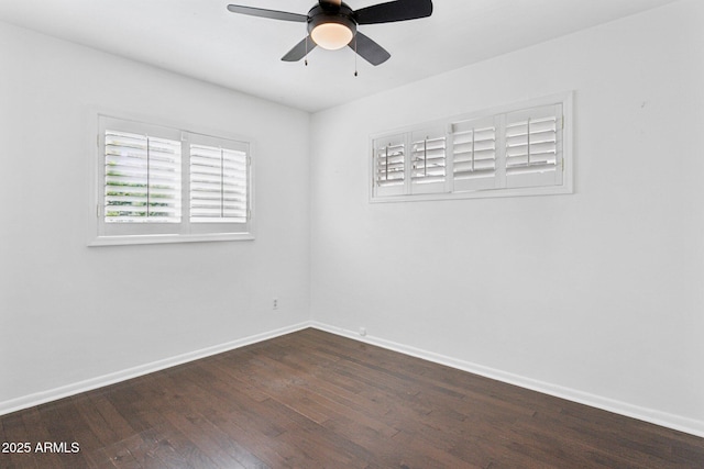 unfurnished room featuring ceiling fan, dark wood-type flooring, and baseboards