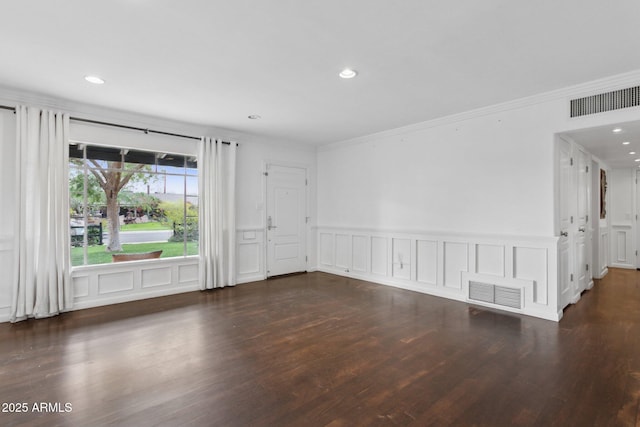 empty room featuring ornamental molding, wood finished floors, and visible vents