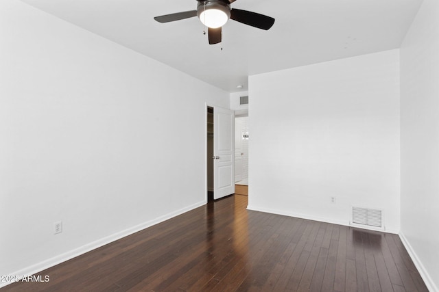 empty room with a ceiling fan, visible vents, dark wood finished floors, and baseboards