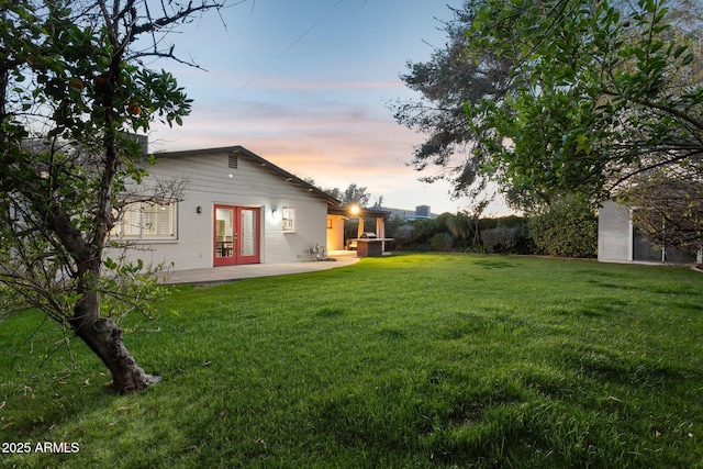 exterior space with french doors, a patio area, and a lawn