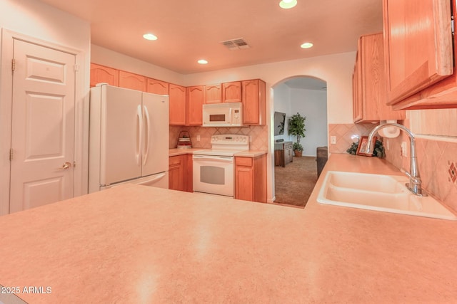 2386 Skyview Dr, Sierra Vista, AZ 85635 - kitchen with white appliances, a sink, arched walkways, light brown cabinets, and tasteful backsplash