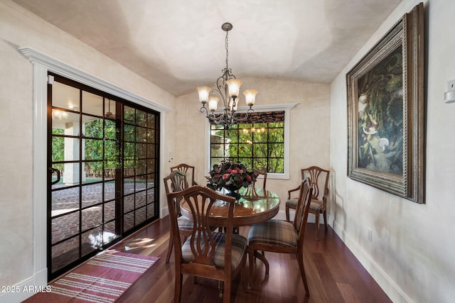 dining room with vaulted ceiling, a chandelier, and wood-type flooring