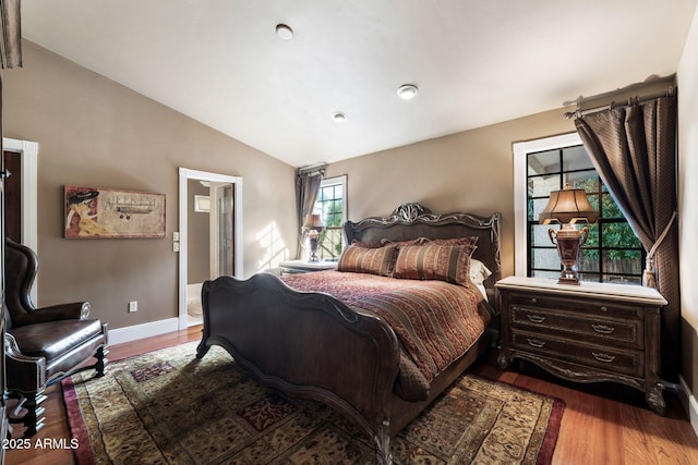 bedroom with vaulted ceiling and wood-type flooring