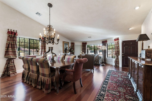 dining area featuring a chandelier, a healthy amount of sunlight, vaulted ceiling, and dark wood-type flooring