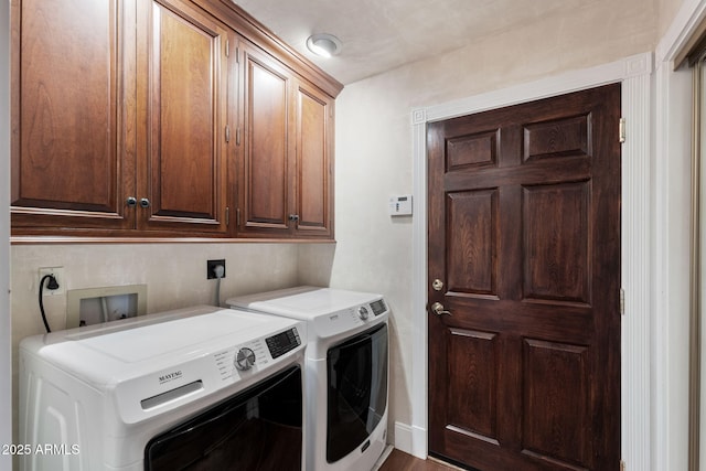 laundry room with washing machine and clothes dryer and cabinets