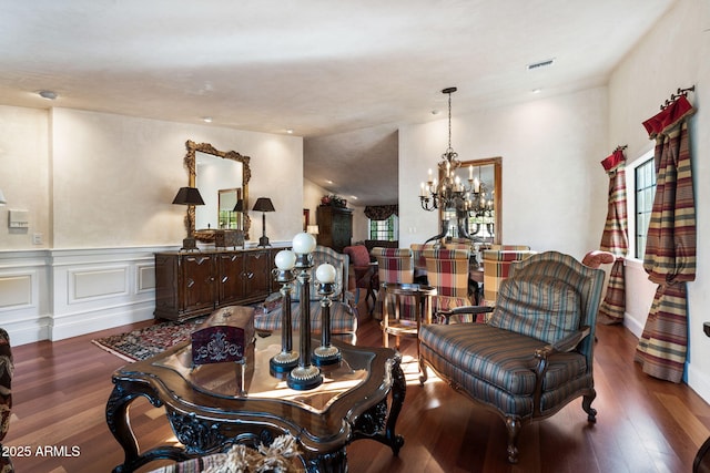 living area featuring vaulted ceiling, a notable chandelier, and dark hardwood / wood-style floors