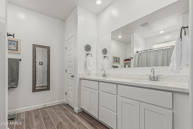 2923 W Shanley Ave, Apache Junction, AZ 85120 - bathroom with double vanity, baseboards, a sink, and wood finished floors