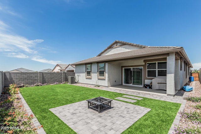 2923 W Shanley Ave, Apache Junction, AZ 85120 - back of house with a patio, a fenced backyard, a tiled roof, an outdoor fire pit, and a yard