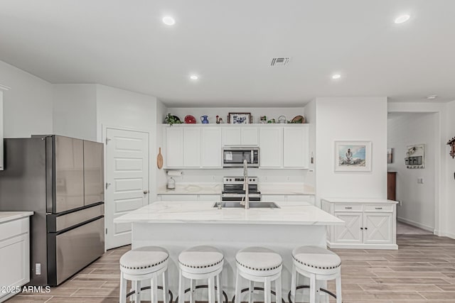 2923 W Shanley Ave, Apache Junction, AZ 85120 - kitchen with a kitchen bar, visible vents, wood finish floors, stainless steel appliances, and recessed lighting