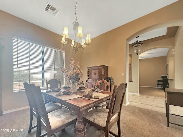 carpeted dining room featuring an inviting chandelier