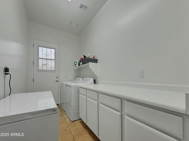 washroom with cabinets, light tile patterned flooring, and separate washer and dryer