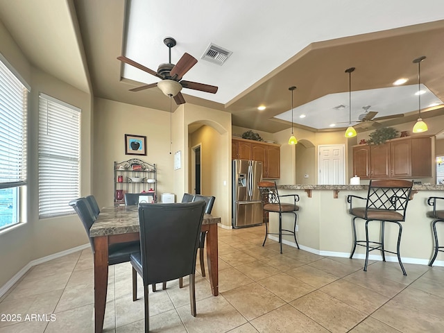 tiled dining space featuring ceiling fan