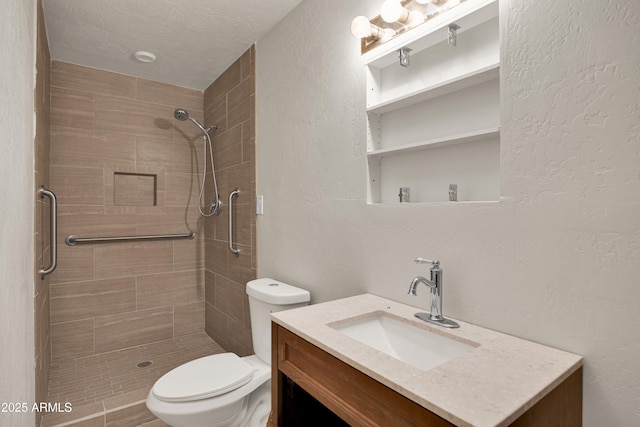 bathroom with vanity, toilet, and a tile shower