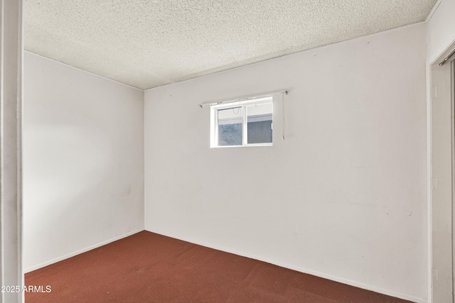 carpeted spare room with a textured ceiling