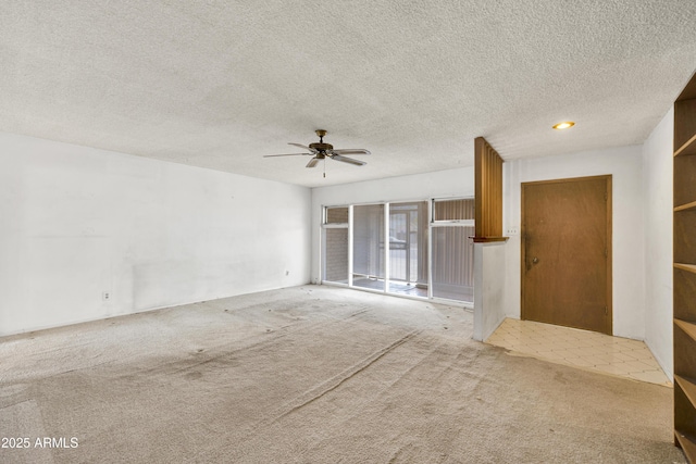 unfurnished living room with light carpet, ceiling fan, and a textured ceiling