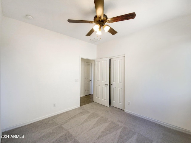 spare room featuring light carpet and ceiling fan