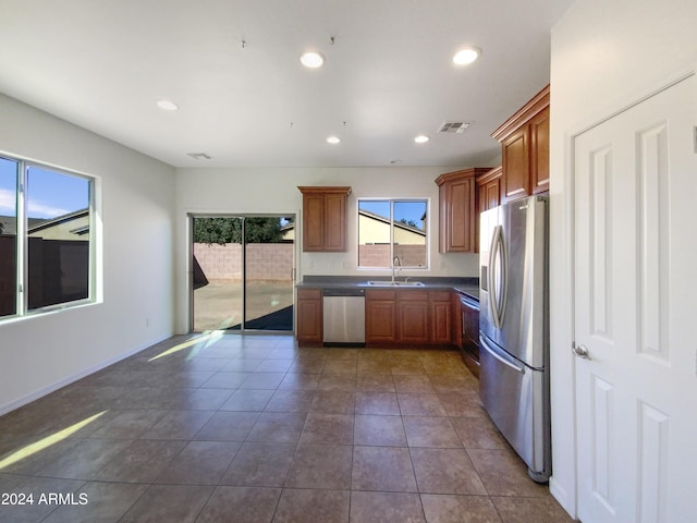 kitchen featuring sink, stainless steel appliances, and dark tile patterned flooring