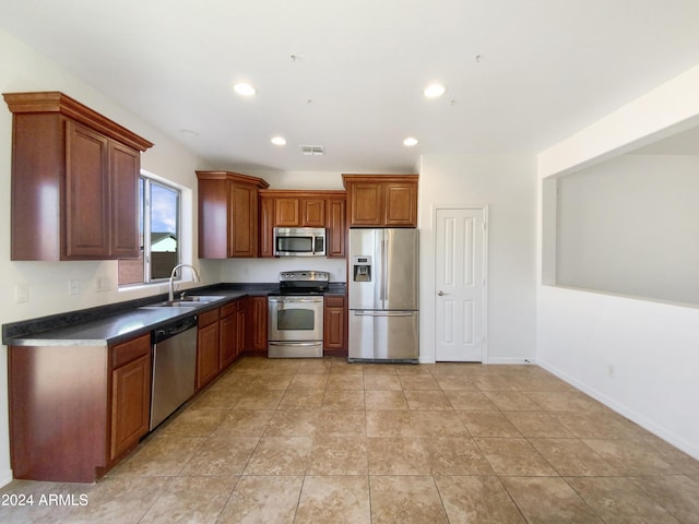 kitchen with appliances with stainless steel finishes, light tile patterned floors, and sink